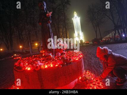 Eine junge ukrainische Frau zündet eine Kerze im Gedenken an die Opfer der Großen Hungersnot (Holodomor) in der Ukraine von 1932-1933, an einem Denkmal für die Opfer des Holodomor in Kiew, Ukraine, 24. November 2018. Die Ukraine markierte 85 Jahre seit der Stalin-Ära große Hungersnot (der Holodomor). Die Hungersnot von 1932-33 fand statt, als die Ernten zurückgingen und die Polizei des sowjetischen Diktators Josef Stalin die brutale Politik der Kollektivierung der Landwirtschaft durch die Beschlagnahme von Getreide und anderen Lebensmitteln durchsetzte. Das Ergebnis war der Tod von mehr als fünf Millionen Menschen, der von vielen als Völkermord angesehen wird. (Foto von NurPhoto) Stockfoto