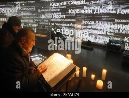 Ein Mann liest die Namen der Opfer, die im Nationalen Buch des Gedächtnisses der Opfer der großen Hungersnot (Holodomor) in der Ukraine von 1932-1933, an einem Denkmal für die Opfer des Holodomor in Kiew, Ukraine, 24 November, 2018. Die Ukraine markierte 85 Jahre seit der Stalin-Ära große Hungersnot (der Holodomor). Die Hungersnot von 1932-33 fand statt, als die Ernten zurückgingen und die Polizei des sowjetischen Diktators Josef Stalin die brutale Politik der Kollektivierung der Landwirtschaft durch die Beschlagnahme von Getreide und anderen Lebensmitteln durchsetzte. Das Ergebnis war der Tod von mehr als fünf Millionen Menschen, der von vielen als Völkermord angesehen wird Stockfoto