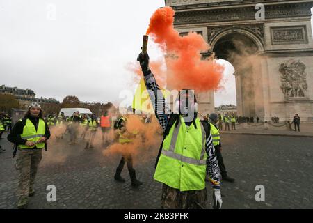 Demonstranten versammeln sich am 1. Dezember 2018 vor dem Arc de Triomphe bei einem Protest der Gelbwesten (Gilets jaunes) gegen steigende Ölpreise und Lebenshaltungskosten in Paris. Tausende von regierungsfeindlichen Demonstranten werden am 1. Dezember 2018 auf den Champs-Elysées in Paris erwartet, eine Woche nachdem eine gewalttätige Demonstration auf der berühmten Straße von brennenden Barrikaden und wütendem Vandalismus gekennzeichnet war, den der französische Präsident mit „Kriegsszenen“ verglich. (Foto von Michel Stoupak/NurPhoto) Stockfoto