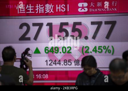 Ein Foto mit Fußgängerpassage an einer elektronischen Anzeigetafel, die den Heng Seng Index in Hongkong, China, zeigt. 3. Dezember 2018. Der Heng Seng Index schloss heute bei 27.182,04, die 675.29Â (2,55%) zugelegt haben. (Foto von Harry Wai/NurPhoto) Stockfoto