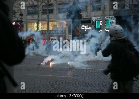 Die Bereitschaftspolizei war während der Demonstration der „Gelbwesten“-Demonstranten gegen steigende Steuern in der Avenue des Champs-Élysées in Paris von Tränengas umgeben. In der vierten Woche in Folge versammelten sich am 8. Dezember 2018 Tausende von Menschen mit gelben Westen auf den Champs-Elysees in Paris, Frankreich, um gegen die Kraftstoffsteuer der französischen Regierung und andere Themen zu protestieren. Die Polizei feuerte Tränengas und verhaftete mehrere Personen. (Foto von Emily Molli/NurPhoto) Stockfoto