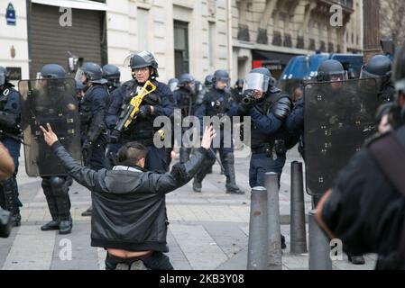 Die Polizei verhaftete während der Demonstration gegen die Steuererhöhungen in der Avenue des Champs-Élysées in Paris einen Demonstranten mit französischer Flagge. In der vierten Woche in Folge versammelten sich am 8. Dezember 2018 Tausende von Menschen mit gelben Westen auf den Champs-Elysees in Paris, Frankreich, um gegen die Kraftstoffsteuer der französischen Regierung und andere Themen zu protestieren. Die Polizei feuerte Tränengas und verhaftete mehrere Personen. (Foto von Emily Molli/NurPhoto) Stockfoto