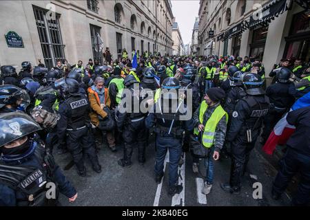 Die Polizei kontrolliert die Demonstranten intensiv. Zusammenstöße und Vandalismus, die zu Tausenden von Verhaftungen geführt haben, darunter mehr als 1.700 am Samstag, den 8. Dezember 2018, als Folge der Proteste der ‘Gelbwesten’, einer Anti-Regierungsbewegung. Straßensperren und viele Aktionen unter den Demonstranten und der Polizei ereigneten sich um den Arc de Triomphe und die Champs Elysees mit kaputten Geschäften, verbrannten oder beschädigten Autos, Straßensperren mit Feuer, Gewalt und viel Tränengasrauch von der Polizei. (Foto von Nicolas Economou/NurPhoto) Stockfoto