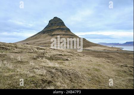 Am 15. Dezember 2018 kann man die Umgebung des Nationalparks Snaefellsnes in der Nähe von Grundarfjordur, Island, betrachten. Mount Kirkjufell wird in den Hintergrund projiziert, während der Kirkjufellsfoss Wasserfall gesehen wird. Der Fluss fließt von einem Vulkan namens Helgrindur und entwässert den Kirkjufellsa Fluss. Der Tourismusanstieg Islands in den letzten fünfzehn Jahren hat zu einem erheblichen wirtschaftlichen Anstieg geführt, der mehr als zehn Prozent des isländischen BIP beitrug. (Foto von Patrick Gorski/NurPhoto) Stockfoto