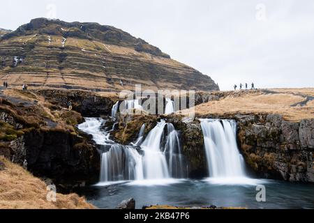 Am 15. Dezember 2018 kann man die Umgebung des Nationalparks Snaefellsnes in der Nähe von Grundarfjordur, Island, betrachten. Mount Kirkjufell wird in den Hintergrund projiziert, während der Kirkjufellsfoss Wasserfall gesehen wird. Der Fluss fließt von einem Vulkan namens Helgrindur und entwässert den Kirkjufellsa Fluss. Der Tourismusanstieg Islands in den letzten fünfzehn Jahren hat zu einem erheblichen wirtschaftlichen Anstieg geführt, der mehr als zehn Prozent des isländischen BIP beitrug. (Foto von Patrick Gorski/NurPhoto) Stockfoto