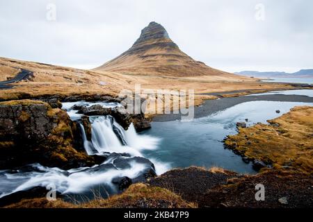 Am 15. Dezember 2018 kann man die Umgebung des Nationalparks Snaefellsnes in der Nähe von Grundarfjordur, Island, betrachten. Mount Kirkjufell wird in den Hintergrund projiziert, während der Kirkjufellsfoss Wasserfall gesehen wird. Der Fluss fließt von einem Vulkan namens Helgrindur und entwässert den Kirkjufellsa Fluss. Der Tourismusanstieg Islands in den letzten fünfzehn Jahren hat zu einem erheblichen wirtschaftlichen Anstieg geführt, der mehr als zehn Prozent des isländischen BIP beitrug. (Foto von Patrick Gorski/NurPhoto) Stockfoto