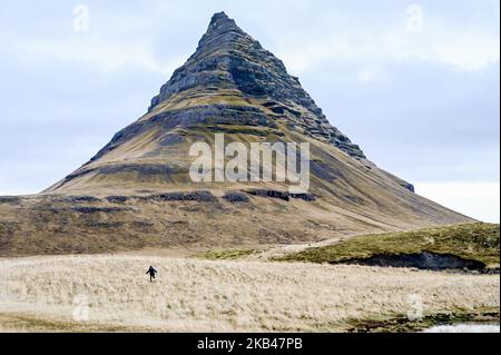 Am 15. Dezember 2018 kann man die Umgebung des Nationalparks Snaefellsnes in der Nähe von Grundarfjordur, Island, betrachten. Mount Kirkjufell wird in den Hintergrund projiziert, während der Kirkjufellsfoss Wasserfall gesehen wird. Der Fluss fließt von einem Vulkan namens Helgrindur und entwässert den Kirkjufellsa Fluss. Der Tourismusanstieg Islands in den letzten fünfzehn Jahren hat zu einem erheblichen wirtschaftlichen Anstieg geführt, der mehr als zehn Prozent des isländischen BIP beitrug. (Foto von Patrick Gorski/NurPhoto) Stockfoto