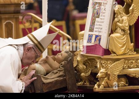 Papst Franziskus küsst eine Statue des Jesuskindes, während er am Montag, den 24. Dezember 2018, die Weihnachtsmesse in der Petersbasilika im Vatikan feiert. (Foto von Massimo Valicchia/NurPhoto) Stockfoto
