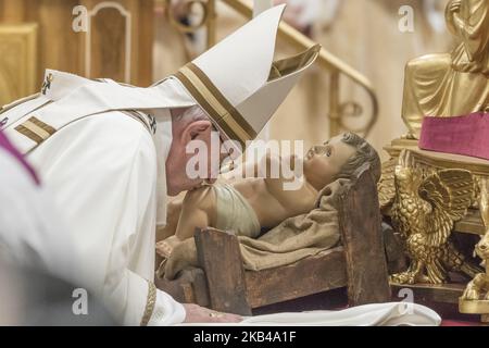 Papst Franziskus küsst eine Statue des Jesuskindes, während er am Montag, den 24. Dezember 2018, die Weihnachtsmesse in der Petersbasilika im Vatikan feiert. (Foto von Massimo Valicchia/NurPhoto) Stockfoto