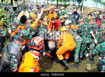 TANJUNG LESUNG, BANTEN, INDONESIEN, DEZ- 24 : Indonesische Soldaten und Retter tragen die Leichen von Tsunami-Opfern im Tanjung Lesung Beach Resort, Indonesien, Montag, 24. Dezember 2018. Ärzte arbeiten daran, Überlebenden zu helfen, und Rettungskräfte suchen nach weiteren Opfern eines tödlichen Tsunamis, der entlang einer indonesischen Meerenge in Strandgebäude einschlug. Die Wellen, die am Samstagabend verängstigte Menschen ins Meer fegten, folgten einem Ausbruch auf Anak Krakatau, einer der berüchtigtsten Vulkaninseln der Welt. Dasril Roszandi (Foto von Dasril Roszandi/NurPhoto) Stockfoto