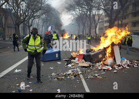 Toulouse, Frankreich - 29. Dezember 2018 - einige gelbe Weste zündet Mülltonnen an, um die Bereitschaftspolizei zu verlangsamen. Der VII. Akt, der als „Revolution“ der Gelbwesten-Bewegung bezeichnet wird, begann friedlich, aber der Protest verwandelte sich schnell in stundenlange Unruhen. Die Bereitschaftspolizei startete mit Tränengaskanistern und feuerte Dutzende von Blitzbällen. Die Bewegung der gelben Jacken begann am 17.. November mit einem Protest gegen die Erhöhung der Steuern auf Ölprodukte. (Foto von Alain Pitton/NurPhoto) Stockfoto