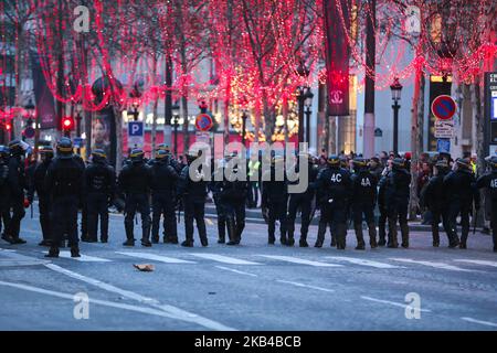 Französische Anti-Aufrührer-Polizeibeamte gehen die Champs Elysee-Durchgangsstraße entlang, als sich am 29. Dezember 2018 regierungsfeindliche Demonstranten der „Gelbwesten“ (Gilets Jaunes) im Zentrum von Paris versammeln. Am 29. Dezember feuerte die Polizei Tränengas auf Demonstranten mit „Gelbwesten“ in Paris, aber die Beteiligung an Runde sieben der Volksproteste, die Frankreich erschüttert haben, schien gering. Die Gelbwesten-Bewegung in Frankreich begann ursprünglich als Protest gegen geplante Treibstoffanhebungen, hat sich aber in einen Massenprotest gegen die Politik des Präsidenten und den Regierungsstil von oben nach unten verwandelt. (Foto von Michel Stoupak/NurPhoto) Stockfoto