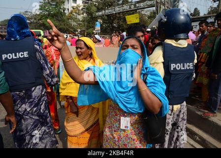 Bangladeschische Bekleidungsarbeiter rufen am 12. Januar 2019 in Dhaka, Bangladesch, bei einer Demonstration zur Forderung höherer Löhne Parolen aus, als sie eine Straße blockieren (Foto: Mamunur Rashid/NurPhoto) Stockfoto