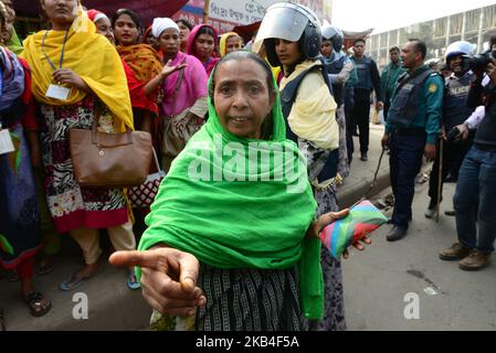 Bangladeschische Bekleidungsarbeiter rufen am 12. Januar 2019 in Dhaka, Bangladesch, bei einer Demonstration zur Forderung höherer Löhne Parolen aus, als sie eine Straße blockieren (Foto: Mamunur Rashid/NurPhoto) Stockfoto