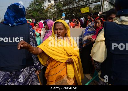 Bangladeschische Bekleidungsarbeiter rufen am 12. Januar 2019 in Dhaka, Bangladesch, bei einer Demonstration zur Forderung höherer Löhne Parolen aus, als sie eine Straße blockieren (Foto: Mamunur Rashid/NurPhoto) Stockfoto