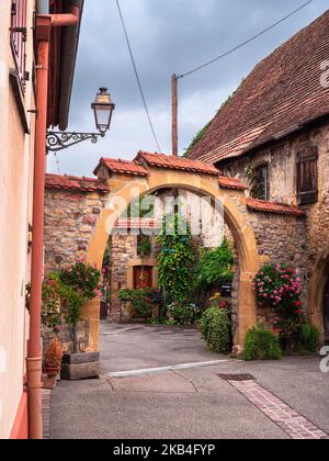 Rouffach, Frankreich - 11. Oktober 2022: Vertikales Foto des traditionellen Hofbogens eines alten Hauses in Rouffach, Elsass, Frankreich Stockfoto
