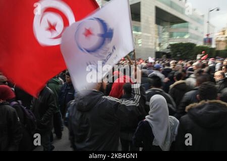 Ein Unterstützer hält eine Flagge Tunesiens und eine Flagge der islamistischen Ennahda-Partei Tunesiens während der Feierlichkeiten zum Tag der Revolution, dem Jahrestag des Sturzes des 23-jährigen Diktators von Tunesien, Zine el-Abidine Ben Ali, Am 14. Januar 2019 auf der Avenue Habib Bourguiba in Tunis. (Foto von Chedly Ben Ibrahim/NurPhoto) Stockfoto