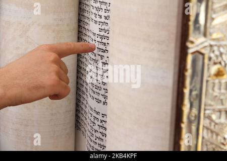 Ein junger Mann Fingerzeig auf einen Satz in einem Buch der Bibel (Sefer Tora), während des Lesens ein beten in einem jüdischen Ritual (Bar-Mizwa-Feier), in The Wailing Stockfoto