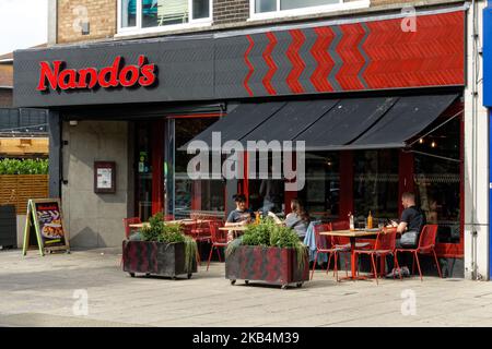 Gäste, die vor dem Restaurant Nando's in London, England, Großbritannien, speisen Stockfoto