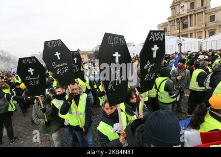 Personen, die eine gelbe Weste trugen und ein Schild mit dem Namen der Demonstranten karrierten, starben bei früheren Demonstrationen, die am 19. Januar 2019 während einer von den gelben Westen (Gilets Jaunes) ausgerufenen Demonstration vor der nationalen Stimme des Hotels über den Invalidendom in Paris gingen. Bewegung in einer Reihe von landesweiten Protesten am zehnten Samstag in Folge gegen hohe Lebenshaltungskosten, staatliche Steuerreformen und für mehr „soziale und wirtschaftliche Gerechtigkeit“. (Foto von Michel Stoupak/NurPhoto) Stockfoto