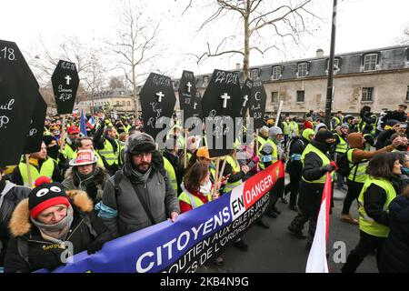 Personen, die eine gelbe Weste trugen und ein Schild mit dem Namen der Demonstranten karrierten, starben bei früheren Demonstrationen, die am 19. Januar 2019 während einer von den gelben Westen (Gilets Jaunes) ausgerufenen Demonstration vor der nationalen Stimme des Hotels über den Invalidendom in Paris gingen. Bewegung in einer Reihe von landesweiten Protesten am zehnten Samstag in Folge gegen hohe Lebenshaltungskosten, staatliche Steuerreformen und für mehr „soziale und wirtschaftliche Gerechtigkeit“. (Foto von Michel Stoupak/NurPhoto) Stockfoto