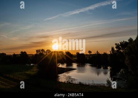 Blick auf einen wunderschönen Sonnenaufgang in Nijmegen, Niederlande, am 6. September 2019. Der Ooijpolder ist ein schönes Gebiet zum Wandern und Entspannen in der Nähe der Waalbrug-Brücke und umgeben vom Waal-Fluss. Das Gebiet liegt östlich der Stadt Nijmegen in der Provinz Gelderland. Es zeichnet sich durch eine weitläufige Landschaft mit kleinen Dörfern, Bauernhöfen und schöner Natur aus. (Foto von Romy Arroyo Fernandez/NurPhoto) Stockfoto