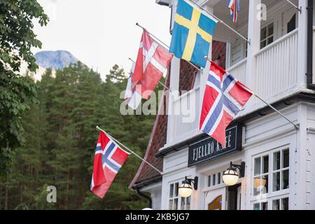 Skandinavische Falken in Valldal oder Valldalen Angeln oder Sylte im Valldal Tal mit traditionellen Häusern, Kirche, Tankstelle, Tunnel, der Fjord umgeben von Bergen in Norddal Gemeinde in Møre Og Romsdal Kreis in Norwegen. Es gibt steile Hügel und alpine Berge mit Gletschern rund um, fließt der Valldola Fluss das fruchtbare Tal mit vielen Wasserfällen in den benachbarten Hügeln geschaffen. Das Dorf ist berühmt und beliebt bei Touristen und Besuchern, da es mit der Fähre zum Sognefjord und Geiranger Fjord und Trollstigen von der anderen Seite, Teil der norwegischen Nationalstraße 63, verbindet. (Foto b Stockfoto