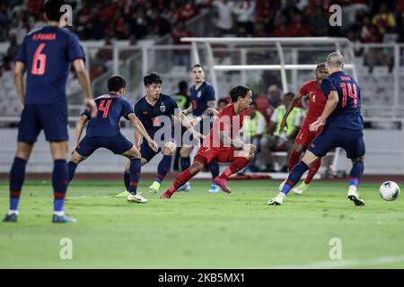 Irfan Bachdim (rot) von Indonesiens in Aktion mit Theerathon Bunmathan von Thailands während des Qualifikationsspiel der FIFA Fußball-Weltmeisterschaft 2022 zwischen Indonesien und Thailand im Gelora Bung Karno-Stadion in Jakarta, Indonesien, 10. September 2019. (Foto von Andrew Gal/NurPhoto) Stockfoto