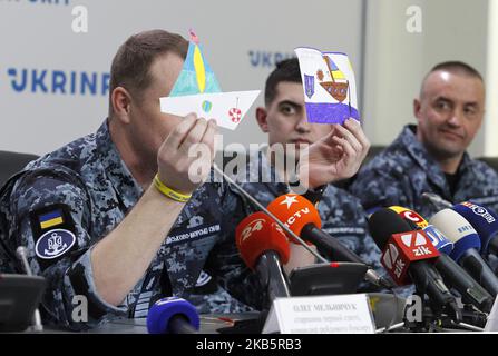 Ukrainischer Seemann , Kommandant der 1. Division der Schiffe der Garde des Überfalls des Marinekommandos, Kapitän des zweiten Ranges, Denis Gritsenko (L) zeigt Zeichnungen von Kindern, Die er als Zeichen der Unterstützung während seiner Haft während einer gemeinsamen Pressekonferenz freigegebener ukrainischer Matrosen in Kiew, Ukraine, am 12. September 2019 erhielt. 24 ukrainische Matrosen, die am 2018. November von Russland in der Nähe der Straße von Kertsch gefangen genommen wurden, und 11 weitere ukrainische politische Gefangene wurden während eines großen Gefangenenaustauschs zwischen der Ukraine und Russland am 07. September 2019 aus Russland in die Ukraine zurückgebracht. (Foto von Stockfoto