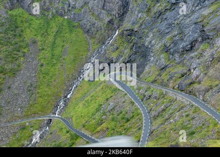 Berühmte Serpentine Scenic Mountain Road Trollstigen oder Trollstigveien, der Trollpfad, eine Bergstraße mit Wasserfällen in der Gemeinde Rauma, Bezirk More Og Romsdal, Norwegen. Die Route ist Teil der Norwegischen Kreisstraße 63, die Andalsnes mit Valldal und Geiranger Fjord verbindet, Trollstigen ist Teil der Norwegischen Panoramastraße Geiranger - Trollstigen. Die Straße ist nur während der Sommersaison geöffnet, sie ist schmal mit scharfen Kurven, aufsteigend 850 Meter, mit einem großen Wasserfall, Stigfossen von einer Höhe von 240 Metern und einer Brücke, Besucherzentrum für Touristen, Besucherplattform. Der Blick auf den Scandi Stockfoto