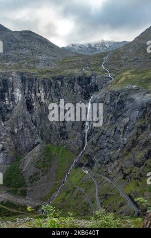 Berühmte Serpentine Scenic Mountain Road Trollstigen oder Trollstigveien, der Trollpfad, eine Bergstraße mit Wasserfällen in der Gemeinde Rauma, Bezirk More Og Romsdal, Norwegen. Die Route ist Teil der Norwegischen Kreisstraße 63, die Andalsnes mit Valldal und Geiranger Fjord verbindet, Trollstigen ist Teil der Norwegischen Panoramastraße Geiranger - Trollstigen. Die Straße ist nur während der Sommersaison geöffnet, sie ist schmal mit scharfen Kurven, aufsteigend 850 Meter, mit einem großen Wasserfall, Stigfossen von einer Höhe von 240 Metern und einer Brücke, Besucherzentrum für Touristen, Besucherplattform. Der Blick auf den Scandi Stockfoto