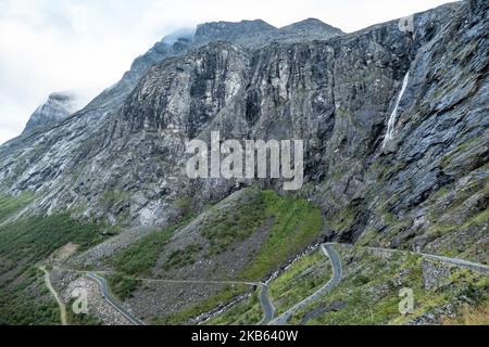 Berühmte Serpentine Scenic Mountain Road Trollstigen oder Trollstigveien, der Trollpfad, eine Bergstraße mit Wasserfällen in der Gemeinde Rauma, Bezirk More Og Romsdal, Norwegen. Die Route ist Teil der Norwegischen Kreisstraße 63, die Andalsnes mit Valldal und Geiranger Fjord verbindet, Trollstigen ist Teil der Norwegischen Panoramastraße Geiranger - Trollstigen. Die Straße ist nur während der Sommersaison geöffnet, sie ist schmal mit scharfen Kurven, aufsteigend 850 Meter, mit einem großen Wasserfall, Stigfossen von einer Höhe von 240 Metern und einer Brücke, Besucherzentrum für Touristen, Besucherplattform. Der Blick auf den Scandi Stockfoto