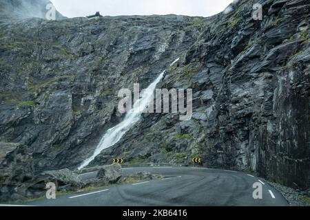 Berühmte Serpentine Scenic Mountain Road Trollstigen oder Trollstigveien, der Trollpfad, eine Bergstraße mit Wasserfällen in der Gemeinde Rauma, Bezirk More Og Romsdal, Norwegen. Die Route ist Teil der Norwegischen Kreisstraße 63, die Andalsnes mit Valldal und Geiranger Fjord verbindet, Trollstigen ist Teil der Norwegischen Panoramastraße Geiranger - Trollstigen. Die Straße ist nur während der Sommersaison geöffnet, sie ist schmal mit scharfen Kurven, aufsteigend 850 Meter, mit einem großen Wasserfall, Stigfossen von einer Höhe von 240 Metern und einer Brücke, Besucherzentrum für Touristen, Besucherplattform. Der Blick auf den Scandi Stockfoto