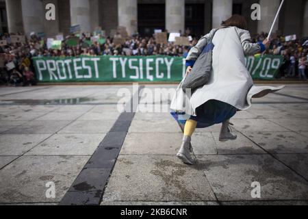 Eine ältere Frau läuft während des Jugendstreiks für das Klima in Warschau am 20. September 2019 auf eine Gruppe protestierender Studenten zu. (Foto von Maciej Luczniewski/NurPhoto) Stockfoto