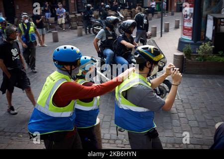 Mitglieder der OPP (Observatory of Police Practices) fotografieren, während Polizisten auf dem Motorrad vorbeikommen. Für den Akt 45 der Gelbwesten-Proteste demonstrierten mehrere Tausende von „Gilets jaunes“ (d. h. Gelbwesten) in Toulouse gegen den französischen Präsidenten Macron, seine Regierung und seine Politik. Sie fordern fiskalische und soziale Gerechtigkeit, mehr Ökologie und das RIC (Bürgerreferendum). Nach nur einem Dutzend Minuten begann die Gendarmerie Mobile (Militär) Tränengaskanister gegen Demonstranten einzusetzen. Die Demonstranten wurden während des gesamten Protestes mit Tränengassern vergast. Toulouse. Frankreich. September 21. 2019. Stockfoto