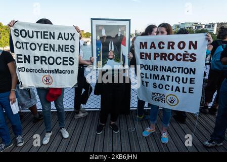 Auf der Fußgängerbrücke von Simone de Beauvoir posieren Aktivisten der NGO ANV-COP21 mit einem von Emmanuel macrons vielen gestohlenen Porträts im Rahmen der „Macron Pick-up“-Kampagne, während an diesem Samstag, dem 21. September 2019, Für Akt 45 der Gelbwesten, die einen großen Tag der nationalen Mobilisierung in Paris mit dem Willen, die Champs-Elysees zurückzuerobern organisiert haben. Nachdem sie den ganzen Morgen vergeblich versucht hatten, sich im Zentrum von Paris zu versammeln, jedes Mal von der Polizei zerstreut, schlossen sich die Gelbwesten und der Schwarze Block dem von Ökologen organisierten marsch für das Klima an. Schnell kam es zu Zusammenstößen zwischen dem Schwarzen Block und dem Gesetz enfo Stockfoto