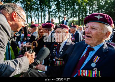 September 22., Oosterbeek. Auf dem Kriegsfriedhof Arnhem Oosterbeek sind mehr als 1750 alliierte Soldaten begraben. Im Rahmen der gedenkfeiern zum 75.. Jahrestag der Operation Market Garden wurde in Anwesenheit von Veteranen, ihren Verwandten und Tausenden von Menschen ein Gedenkgottesdienst abgehalten. Traditionell legen „Blumenkinder“ aus der Gemeinde Remkum Blumen an die Grabsteine, in diesem Jahr waren es auch Kinder aus anderen Ländern, die Blumen an die Grabsteine legen. An jedem Grab befindet sich ein weißer Steinbogen. Auf dem Ehrenfeld steht ein „Opferkreuz“ aus Portland-Stein, auf dem eine Bronze angebracht ist Stockfoto