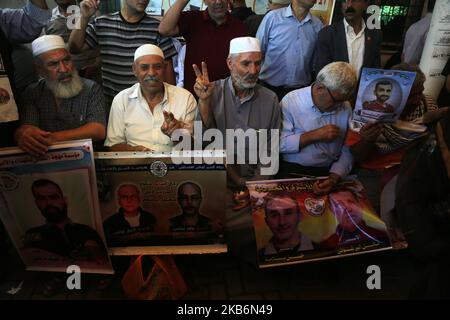 Angehörige palästinensischer Gefangener, die in israelischen Gefängnissen festgehalten werden, halten während eines Protestes vor dem Roten Kreuz in Gaza-Stadt am 23. September 2019 Fotos bereit. (Foto von Majdi Fathi/NurPhoto) Stockfoto