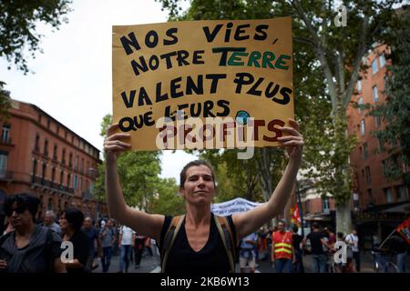 Eine Frau hält ein Plakat über unser Leben, unsere Erde ist wertvoller als ihre Gewinne.“ mit der Aufschrift „Tausende von Demonstranten gingen auf die Straßen von Toulouse, um eine Demonstration zu organisieren, die von mehreren Gewerkschaften (CGT, UNSA, Sud, UNL, UNEF) aufgerufen wurde. Die Demonstranten fordern den Rückzug der neuen Rentenreform (Alter, Rente, Bedingungen usw.). Macrons Regierung schlägt einen Wechsel zwischen einem Renten- und Rentensystem nach dem Entgelt durch ein Kapitalisierungssystem vor. Die französische Regierung will auch eine Vereinheitlichung aller Rentensysteme in Frankreich. Toulouse. Frankreich. September 24. 2019. (Foto von Alain Pitton/NurPhoto) Stockfoto