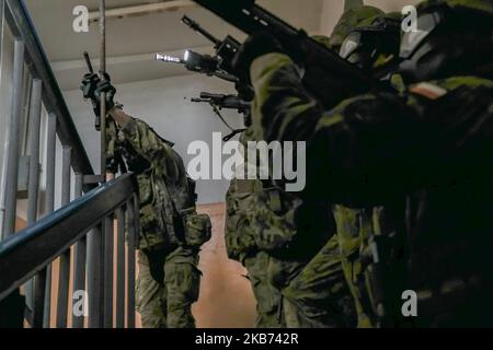 US-Soldaten, die dem Bataillon 3., dem Kavallerieregiment 8., dem Kampfteam der Panzerbrigade 3. und der Kavalleriedivision 1. (3-1 ABCT) zugewiesen wurden, operativ von der Infanterie-Division 1. kontrolliert (ID 1) Während einer NATO-Übung für taktische Operationen in Komorowo, Polen, am 26. Oktober 2022, treten polnische Soldaten, die der masowischen Brigade der Territorialen Verteidigungsstreitkräfte von 5. zugewiesen wurden, eine Treppe hoch. Die 3-1 ABCT ist unter anderem der 1 ID zugeordnet und arbeitet stolz mit NATO-Verbündeten und regionalen Sicherheitspartnern zusammen, um dem V-Corps, Amerikas vorwärts entsandt Korps, kampfglaubwürdige Kräfte zur Verfügung zu stellen Stockfoto