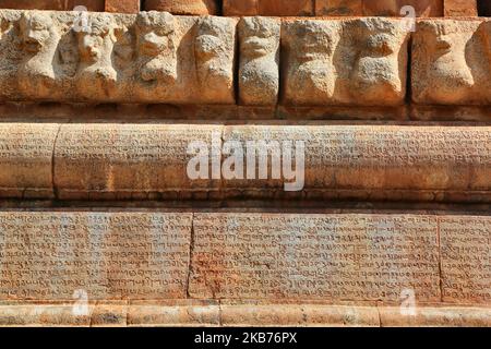 Alter Text, der in den Stein des Brihadeeswarar Temple (auch bekannt als Brihadisvara Tempel, Brihadishvara Tempel, großer Tempel, RajaRajeswara Tempel, Rajarajeswaram und Peruvudayar Tempel) geschnitzt ist ein Hindu-Tempel, der Lord Shiva gewidmet ist und sich in Thanjavur, Tamil Nadu, Indien befindet. Der Tempel ist einer der größten Tempel in Indien und ist ein Beispiel für dravidische Architektur, die während der Chola-Zeit von Raja Raja Chola I erbaut und 1010 n. Chr. fertiggestellt wurde. Der Tempel ist über 1000 Jahre alt und ist Teil des UNESCO-Weltkulturerbes, bekannt als die "Großen Lebenden Chola-Tempel", die aus dem Brihadeeswar bestehen Stockfoto