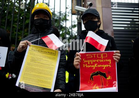 Während einer Kundgebung gegen die chinesische Regierung am 29. September 2019 in Warschau, Polen, werden Demonstranten mit Schildern und polnischen Fahnen gesehen. Demonstranten versammelten sich vor der chinesischen Botschaft in Warschau, um ihre Solidarität mit Hongkongers zu zeigen und verurteilten Hongkong und die chinesische Regierung für die Unterdrückung von Freiheit und Menschenrechten. (Foto von Aleksander Kalka/NurPhoto) Stockfoto