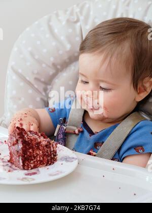 Erste Geburtstagsfeier und zum ersten Mal essen Kuchen für diesen kleinen Jungen Stockfoto