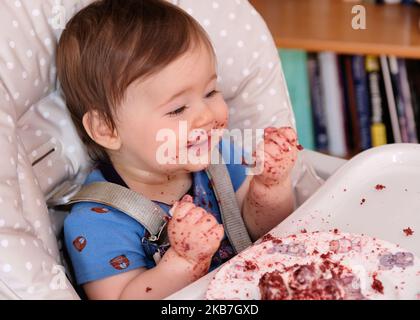 Erste Geburtstagsfeier und zum ersten Mal essen Kuchen für diesen kleinen Jungen Stockfoto