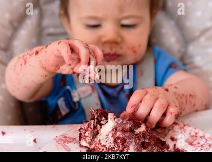 Erste Geburtstagsfeier und zum ersten Mal essen Kuchen für diesen kleinen Jungen Stockfoto