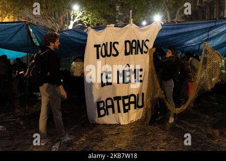 Umweltaktivisten schützen sich in der Nacht mit großen Plastikplanen und Spruchbändern vor Regen, von denen eines am Montag, den 7. Oktober 2019, mit der Aufschrift „Wir sind alle im selben Boot“ Als mehrere hundert Aktivisten der Ökologen der internationalen Bewegung Extinction Rebellion (XR) die Besetzung des Place du Chatelet und der Pont au Change in Paris starteten, um die Bevölkerung und die französischen und internationalen Behörden angesichts der untätigen Regierungen auf die Klimanotstand aufmerksam zu machen Der globalen Erwärmung ins Auge sehen. Diese Aktion fällt in den Rahmen der Internationalen Aktion Stockfoto