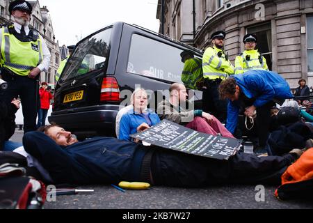 Mitglieder der Aktivistengruppe Extinction Rebellion (XR) blockieren den Ausgang des Trafalgar Square in Whitehall am Eröffnungstag der lang geplanten „Internationalen Rebellion“ in London, England, am 7. Oktober 2019. Die Gruppenmitglieder beabsichtigen, bis mindestens nächsten Samstag, den 19. Oktober, 12 Standorte rund um Regierungsgebäude in Westminster zu besetzen, um das Gebiet zu „schützen“, um die Gesetzgeber zu drängen, weitere und schnellere Maßnahmen zu ergreifen, um den Verlust an biologischer Vielfalt zu stoppen und die Treibhausgasemissionen zu senken. Ähnliche Blockaden durch Aussterben Rebellion in der Stadt im April, an Orten wie Oxford Circus und Wa Stockfoto