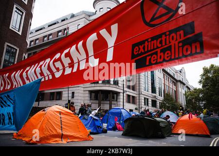 Zelte für Mitglieder der Klima-Aktivisten-Gruppe Extinction Rebellion (XR) blockieren die Horseferry Road am Eröffnungstag der lang geplanten "Internationalen Rebellion" in London, England, am 7. Oktober 2019. Die Gruppenmitglieder beabsichtigen, bis mindestens nächsten Samstag, den 19. Oktober, 12 Standorte rund um Regierungsgebäude in Westminster zu besetzen, um das Gebiet zu „schützen“, um die Gesetzgeber zu drängen, weitere und schnellere Maßnahmen zu ergreifen, um den Verlust an biologischer Vielfalt zu stoppen und die Treibhausgasemissionen zu senken. Ähnliche Blockaden durch Aussterben Rebellion in der Stadt im April, an Orten wie Oxford Circus und Waterloo Bridge Stockfoto