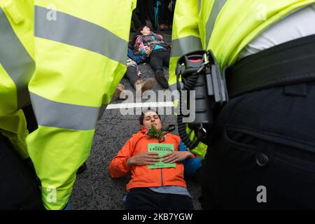 Umweltaktivistin von Extinction Rebellion liegt am 08. Oktober 2019 in London, England, auf dem Boden und blockiert die Straße vor dem Innenministerium. Die Demonstranten planen, die Regierungsgebäude in Westminster im Rahmen der geplanten zweiwöchigen Aktion zu besetzen und fordern entschlossenes und sofortiges Handeln angesichts der klimatischen und ökologischen Notlage. (Foto von Wiktor Szymanowicz/NurPhoto) Stockfoto