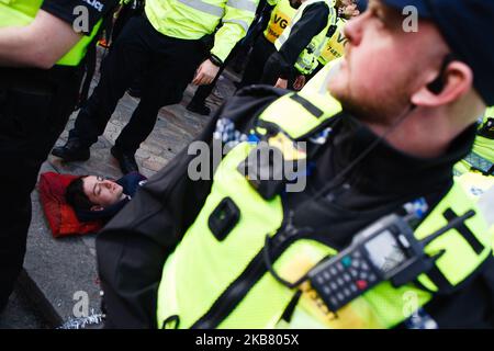 Polizeibeamte umgeben ein Mitglied der Bewegung Extinction Rebellion (XR), die am dritten Tag der 'Internationalen Rebellion' der Gruppe in London, England, am 9. Oktober 2019 in der Victoria Street protestiert. Polizeibeamte haben heute weiterhin Demonstranten und Zelte von Standorten in ganz Westminster abgestellt, wobei Aktivisten gestern gewarnt wurden, dass sie in einen dafür vorgesehenen Protestbereich um die Nelson-Säule auf dem Trafalgar Square umziehen oder verhaftet werden müssen. Ähnliche Blockaden durch das Aussterben Rebellion im April, an Orten wie Oxford Circus und Waterloo Bridge, sah mehr als 1.000 ar Stockfoto